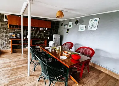 a dining room with a table and chairs and a kitchen at Manas Valley View bungalow by Xacro Xperiences in Kodaikānāl