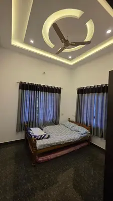 a bedroom with a bed and a ceiling with a ceiling fan at Serahs Homestay in Agali