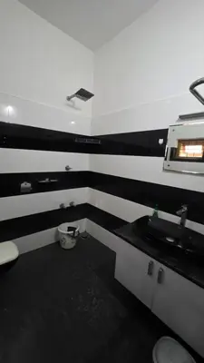 a bathroom with black and white stripes on the wall at Serahs Homestay in Agali