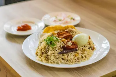 a plate of rice on a table at Blue Bell Hotel in Nedumbassery