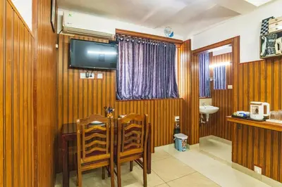 a bathroom with wooden walls and a sink and a toilet at Blue Bell Hotel in Nedumbassery