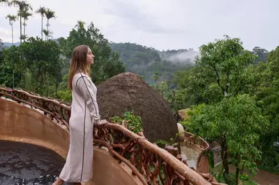 a woman standing on a bridge over a river at Toroland Munnar in Viripara