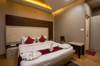 a bedroom with a large bed with red and white pillows at Paradise Point Ooty in Ooty