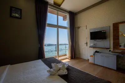 a bedroom with a large window with a view of the ocean at Paradise Point Ooty in Ooty