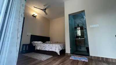 a room with a bed and a glass door with a mirror at Lotus Exotica Homestay in Suntikoppa