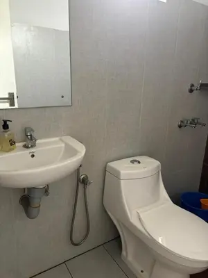 a bathroom with a white toilet and a sink at Abrigo Delamar in Kozhikode