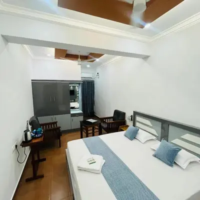 a bedroom with a bed and a flat screen tv at Enroute Delight Residency in Kotamangalam