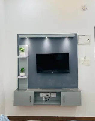 a flat screen tv on a wall in a living room at Enroute Delight Residency in Kotamangalam