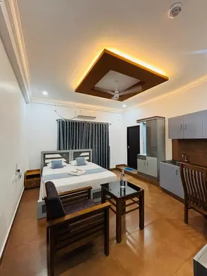 a bedroom with a bed and a table in a room at Enroute Delight Residency in Kotamangalam