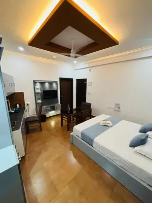 a bedroom with a bed and a desk and a television at Enroute Delight Residency in Kotamangalam