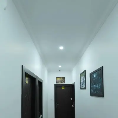 a hallway with two black doors and a white wall at Enroute Delight Residency in Kotamangalam