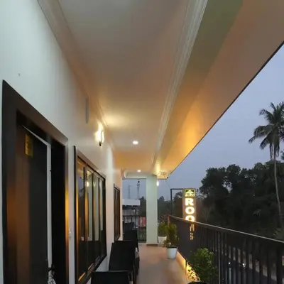 a balcony of a building with chairs on it at Enroute Delight Residency in Kotamangalam