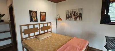 a bedroom with a bed and pictures on the wall at wild grove resorts in Varagampadi