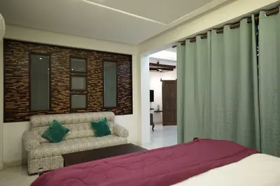 a bedroom with a bed and a couch and curtains at Palamattam Villa Homestay,Angamaly, Kochi, Airport in Cochin