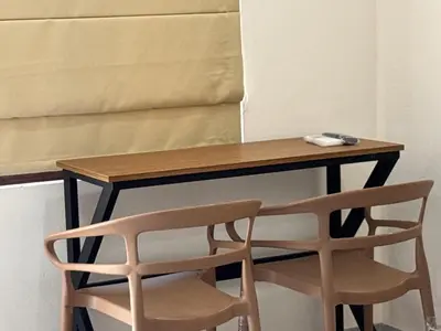 a wooden desk with two chairs next to it at Thamarassery INN luxury and budget Rooms in Thamarassery