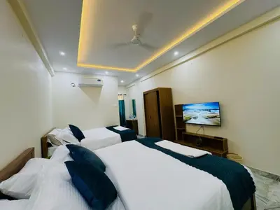 a hotel room with two beds and a tv at Thamarassery INN luxury and budget Rooms in Thamarassery
