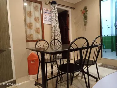 a table and chairs in a room with a window at River View Homestsy in Vālpārai