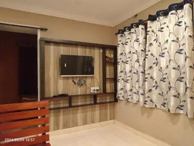 a living room with a window with a television at River View Homestsy in Vālpārai