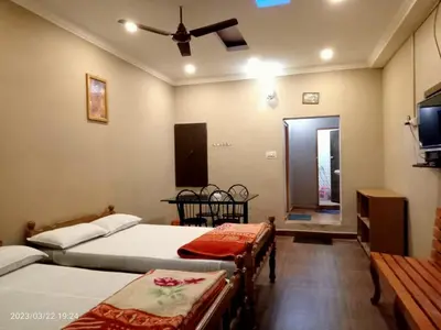 a bedroom with two beds and a ceiling fan at River View Homestsy in Vālpārai
