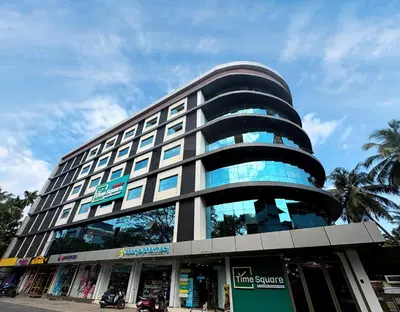 a tall building with a lot of windows at Nexstay Time Square in Kozhikode