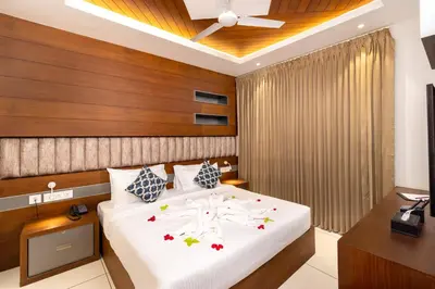 a bedroom with a large bed with a ceiling fan at Nexstay Time Square in Kozhikode