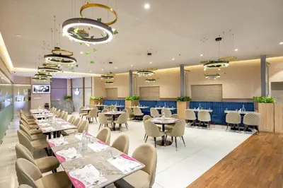 a dining room with tables and chairs at Nexstay Time Square in Kozhikode
