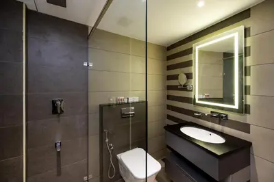 a bathroom with a sink and a toilet and a mirror at Nexstay Time Square in Kozhikode