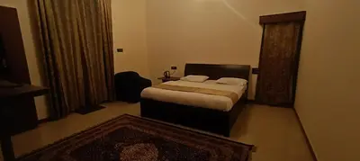 a bedroom with a bed and a chair in it at Jungle view in Coonoor
