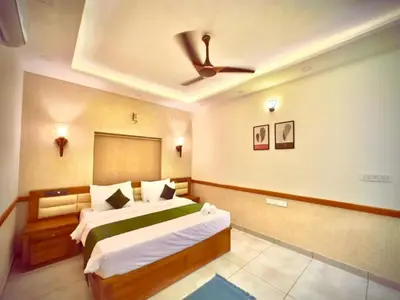 a bedroom with a bed and a ceiling fan at Aqualuxe Premium Suites in Vythiri