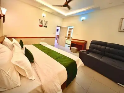 a bedroom with a large bed and a couch at Aqualuxe Premium Suites in Vythiri