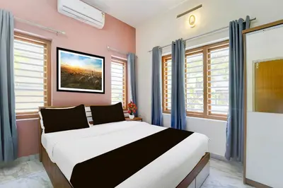 a bedroom with a large bed in a room with windows at Super Collection O Westhill Near Govt Engg College in Calicut