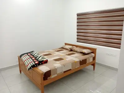 a bed sitting in a room with a window at Naduthotty Holiday Home in Viripara