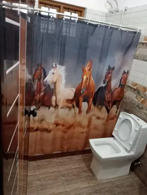 a bathroom with a shower curtain of horses at Naduthotty Holiday Home in Viripara