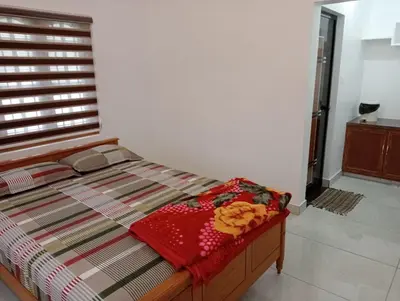 a bed in a room with a window with flowers on it at Naduthotty Holiday Home in Viripara