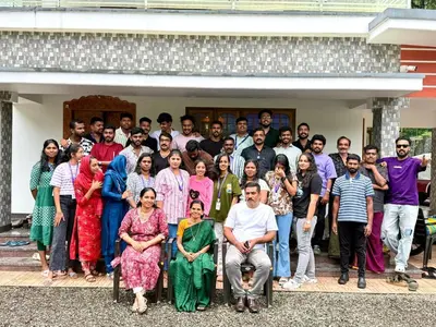 a group of people posing for a picture in front of a house at Naduthotty Holiday Home in Viripara