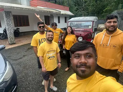 a group of people in yellow shirts posing for a picture at Naduthotty Holiday Home in Viripara