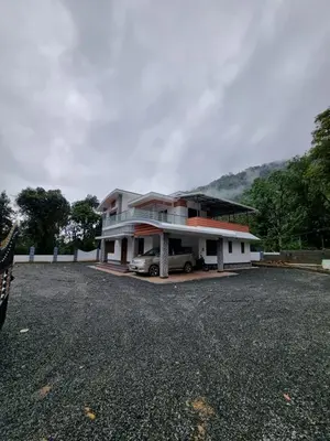 a house with a car parked in front of it at Naduthotty Holiday Home in Viripara
