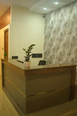 a reception desk with a potted plant on top of it at ALPHA inn in Alwaye