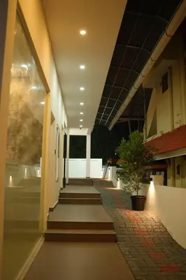 a hallway of a building with stairs and a plant at ALPHA inn in Alwaye