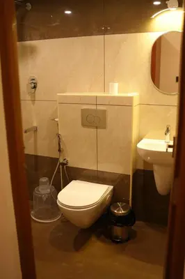 a bathroom with a toilet and a sink at ALPHA inn in Alwaye