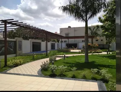 a courtyard with a palm tree and a building at Regi's Adobe - Entire Place -Service Apartment for Rent in Coimbatore