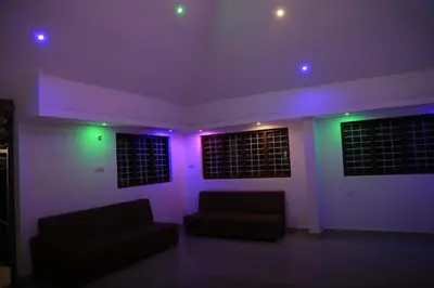 a living room with purple and green lights at Blizzard Pool Villa in Padinjarathara