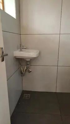 a bathroom with a sink on a wall at Ashirvad Homes in Mannārakkāt