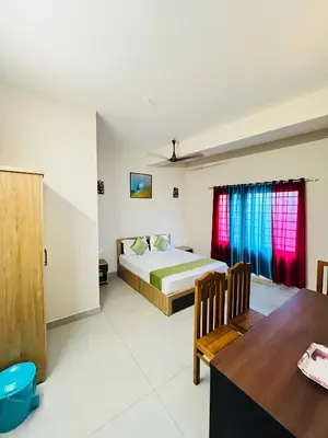 a bedroom with a bed and a dining table at Marhaba inn in Kozhikode