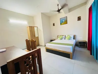 a bedroom with a bed and a desk in it at Marhaba inn in Kozhikode