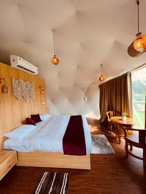 a bedroom with a large bed and a table at Wildglamps Athirappilly in Athirappilly