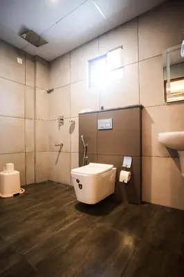 a bathroom with a bath tub and a sink at AJ Wayanad Suites in Kalpetta
