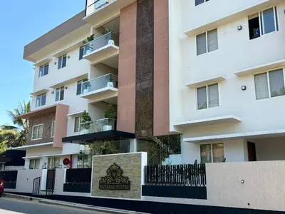 an apartment building with a sign in front of it at AJ Wayanad Suites in Kalpetta