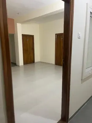 an empty room with wooden doors and a white floor at Subam Residency in Singānallūr