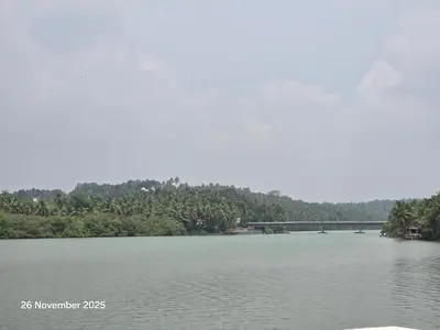 a large river with a bridge in the background at Thiruthi Homestay in Vallikunnu